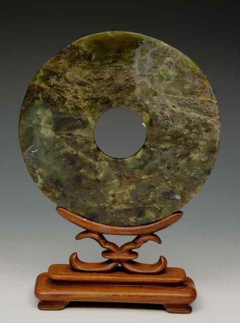 Appraisal: A SPINACH JADE BI DISC on a hardwood stand diameter