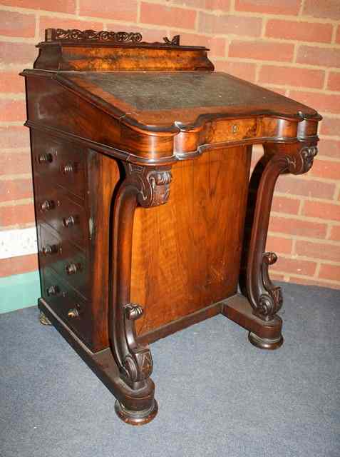 Appraisal: A VICTORIAN WALNUT DAVENPORT with marquetry decoration and scroll supports