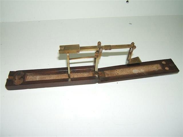 Appraisal: A GEORGE III MAHOGANY AND BRASS GUINEA SCALE with paper