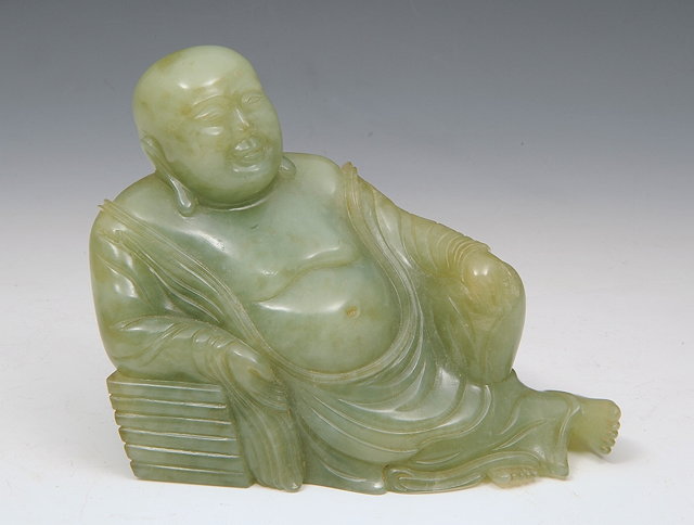 Appraisal: A CHINESE CARVED JADE FIGURE of a recumbent Hotei late