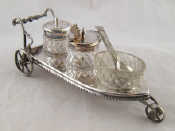 Appraisal: A silver plate three wheeled cruet trolley with cut glass