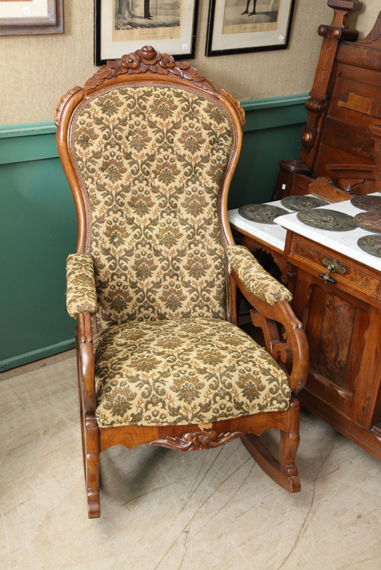 Appraisal: VICTORIAN ROCKER Walnut with a carved crest scrolled arms and