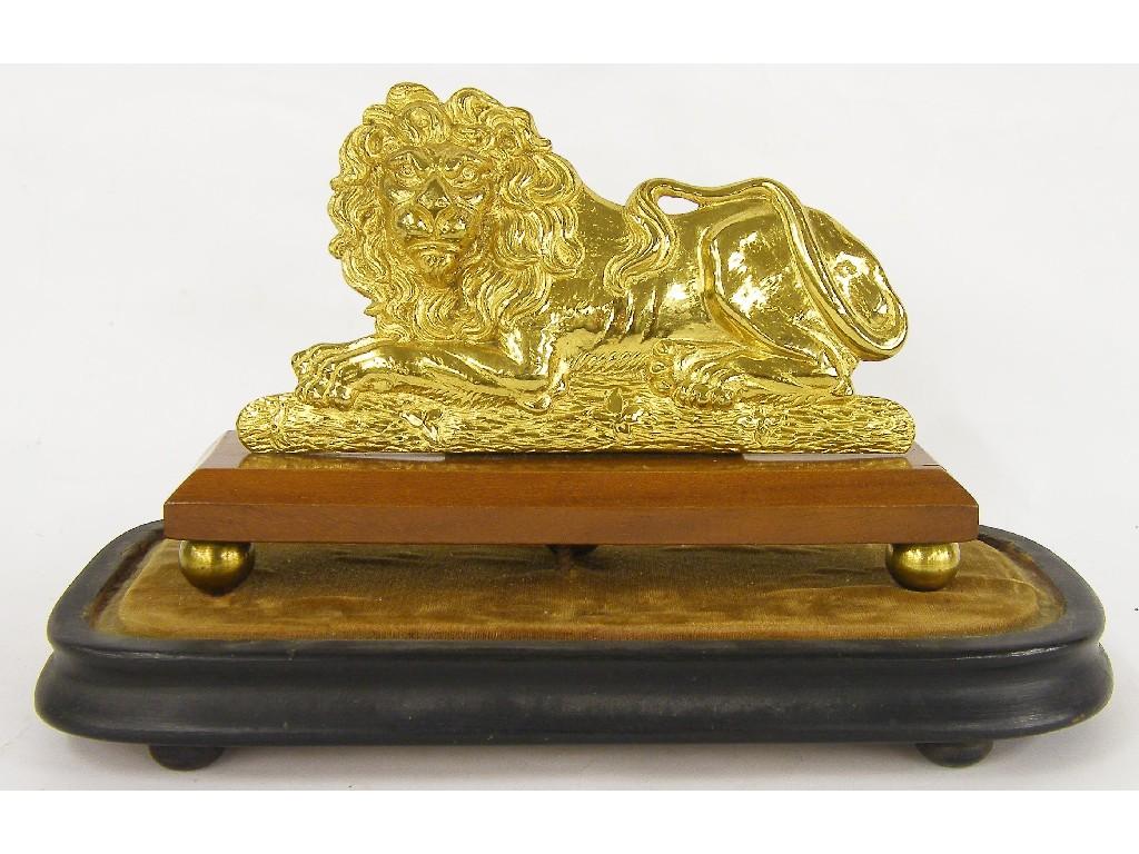 Appraisal: Gilded metal recumbent lion upon a rectangular canted stand and