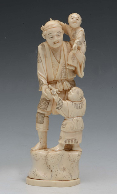 Appraisal: A JAPANESE CARVED IVORY OKIMONO a figure holding a child