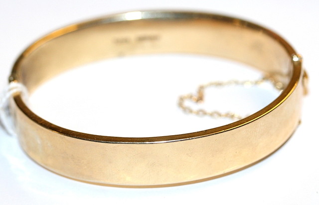 Appraisal: A CT GOLD HINGED BANGLE with engraved scroll and leaf