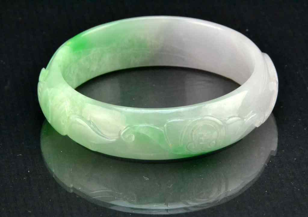 Appraisal: Chinese Carved Jadeite Bangle BraceletFinely carved to depict a continues