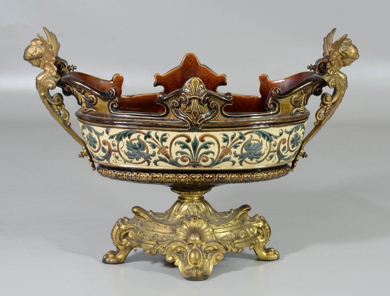 Appraisal: Elliptical unmarked majolica centerpiece patinated white metal winged angel handles