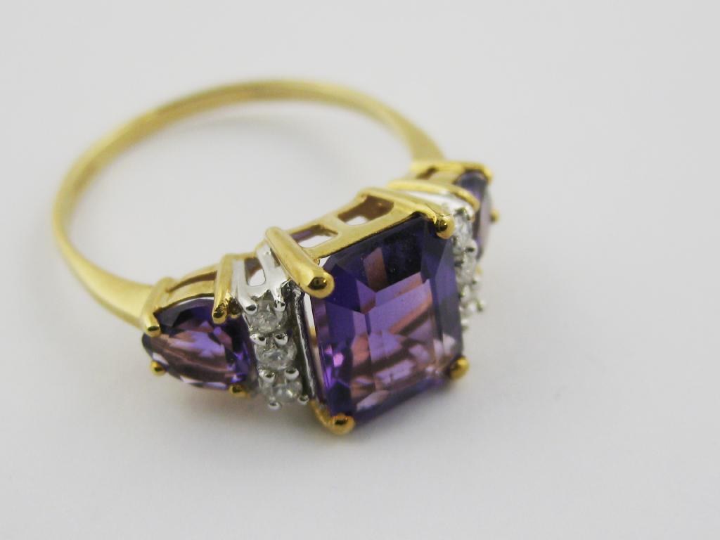 Appraisal: A three stone Amethyst Ring claw-set central step-cut stone and