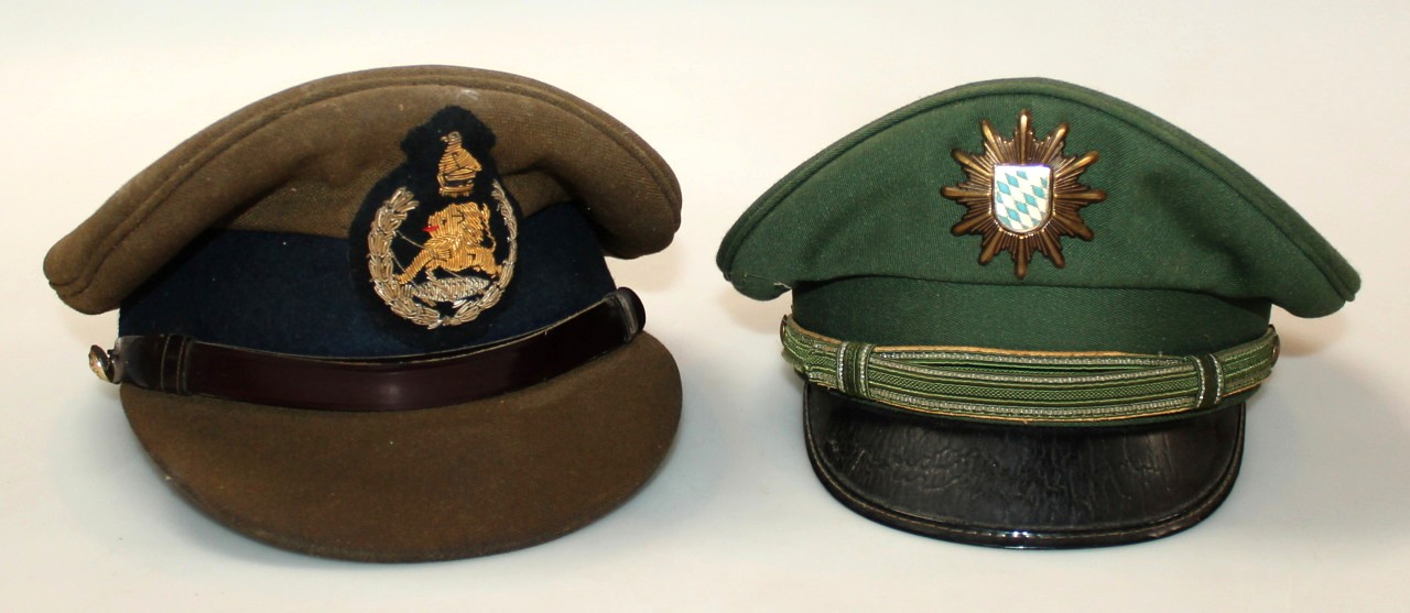 Appraisal: A thC peaked cap in green velvet with police style