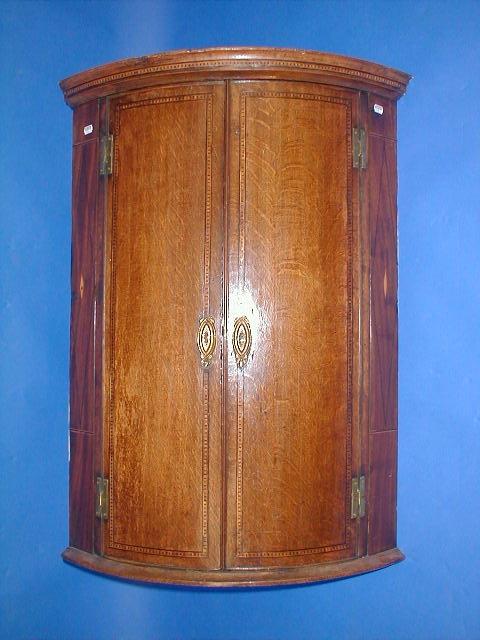 Appraisal: A George III oak bow front hanging corner cupboard with