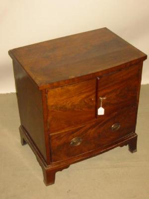 Appraisal: A MAHOGANY BEDSIDE CABINET of bowed form the banded top