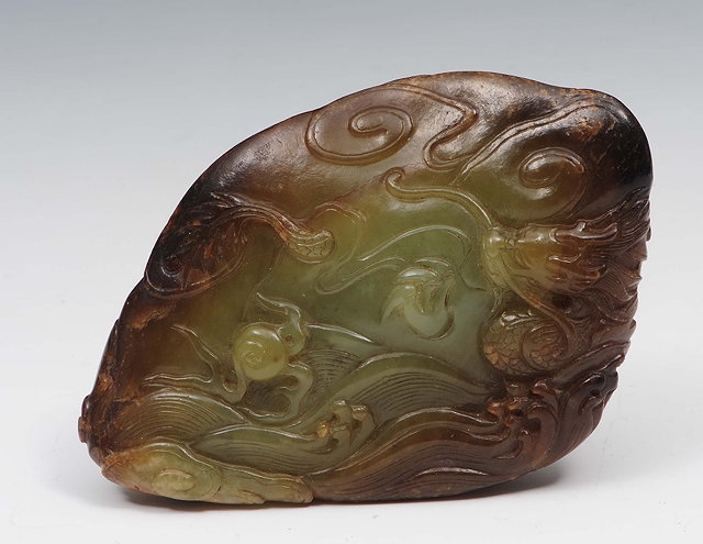 Appraisal: A Chinese green and brown jade boulder th Centurycarved with