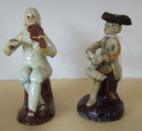 Appraisal: Two pottery figures modelled as musicians cm high