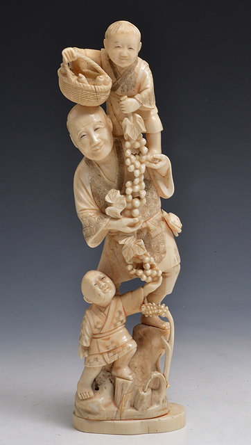 Appraisal: A JAPANESE WALRUS CARVING GROUP OF A FARMER standing upon