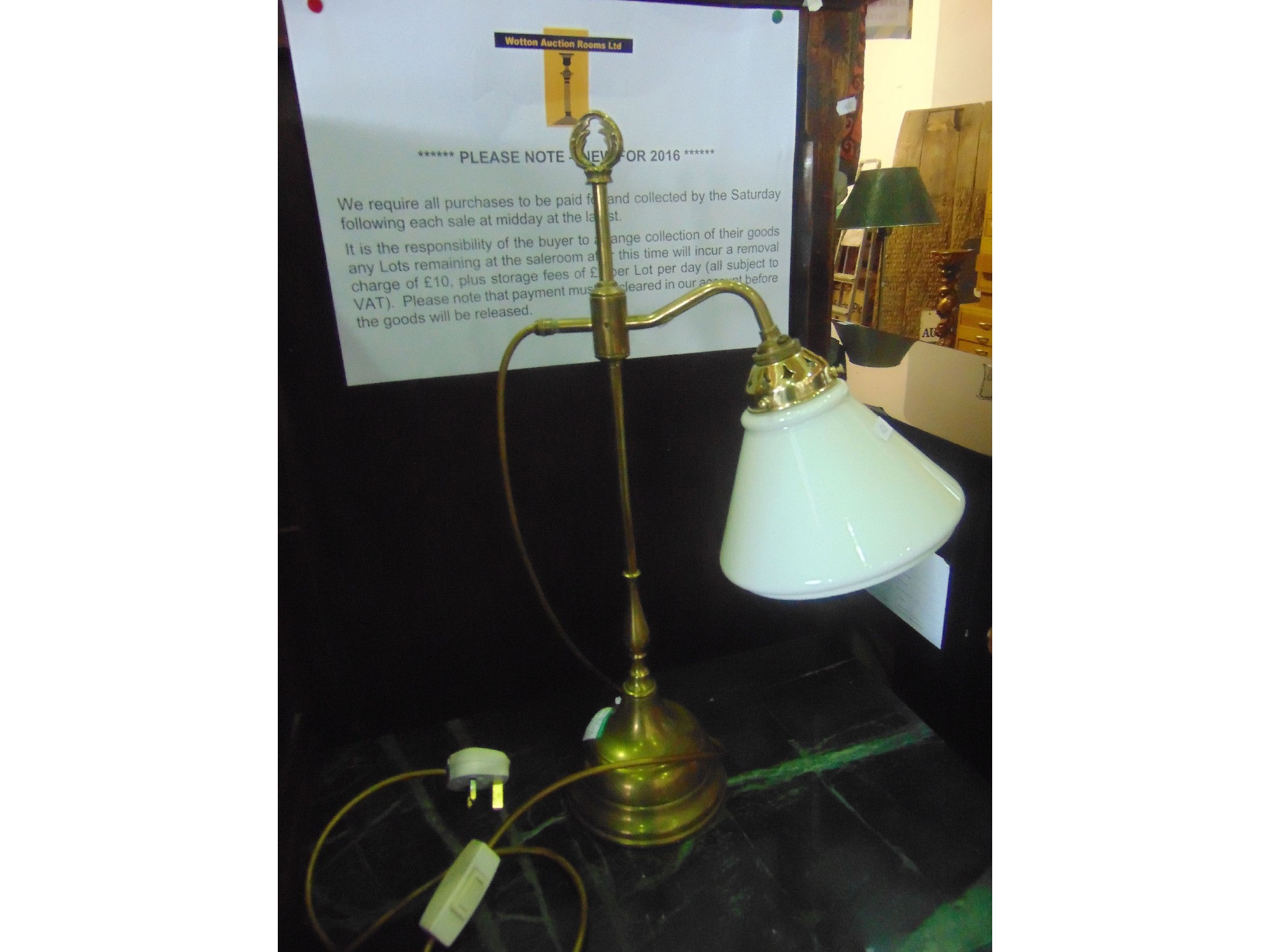 Appraisal: An adjustable brass table lamp with milk glass shade and