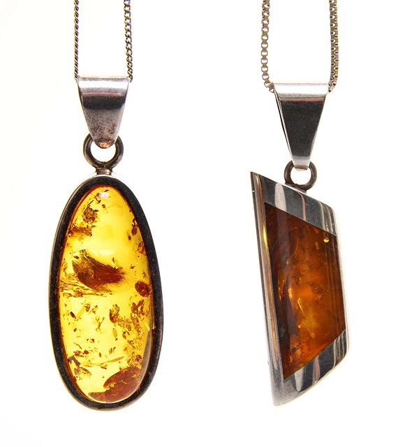 Appraisal: A CONTEMPORARY WHITE METAL MOUNTED AMBER PENDANT with possible insect