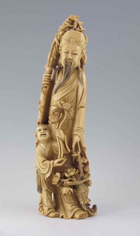 Appraisal: CARVED IVORY WISEMAN WITH CHILD Figure of elder with staff