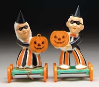 Appraisal: PARTY GOERS ON WHEELS Plastic man and woman holding pumpkins