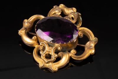 Appraisal: A Victorian amethyst brooch the oval amethyst in scrolling yellow