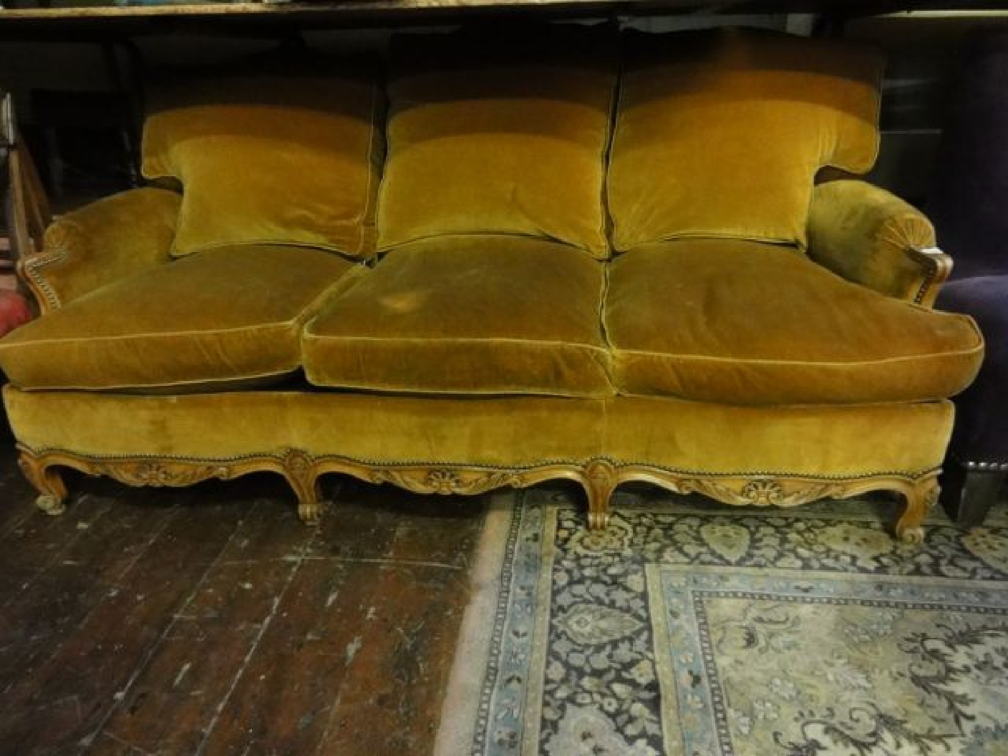 Appraisal: A three seat sofa with feather filled upholstery with carved