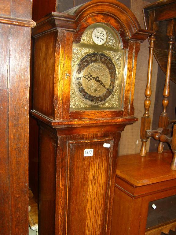 Appraisal: An oak grandmother clock with anodised dial with relief decoration