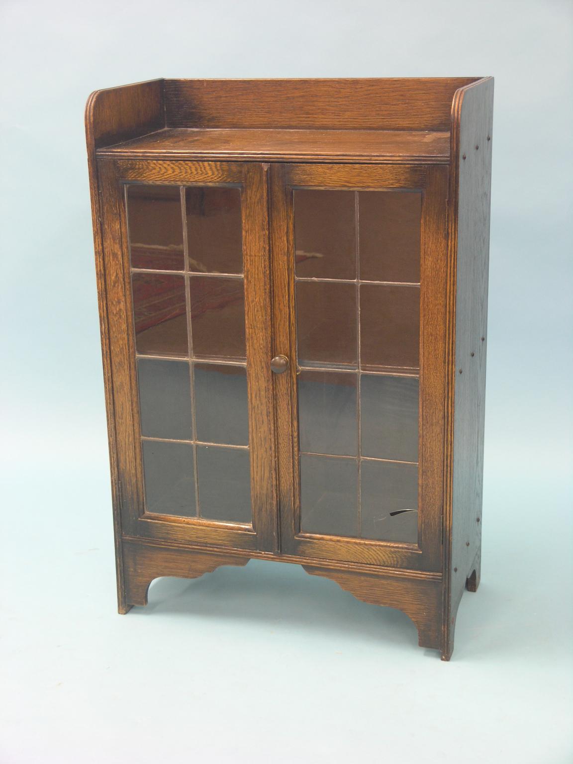 Appraisal: A solid dark oak dwarf bookcase single shelf enclosed by