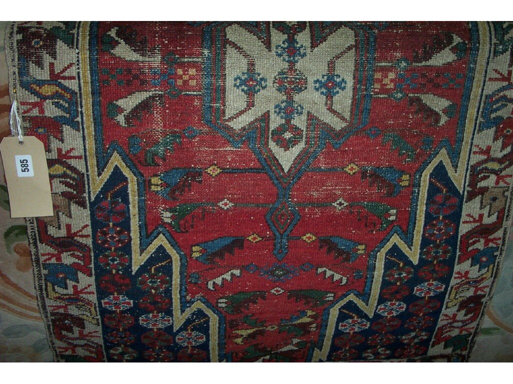 Appraisal: A small red ground Eastern wool rug with polychrome geometric