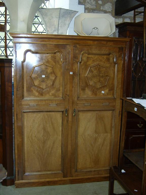 Appraisal: A continental walnut wardrobe enclosed by two panelled doors with