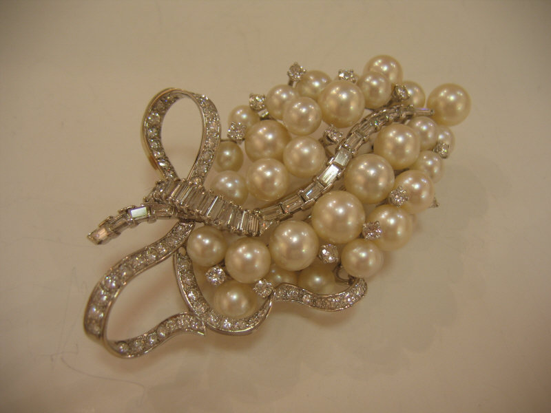 Appraisal: DIAMOND AND PEARL BROOCH A flowing ribbon design of diamonds