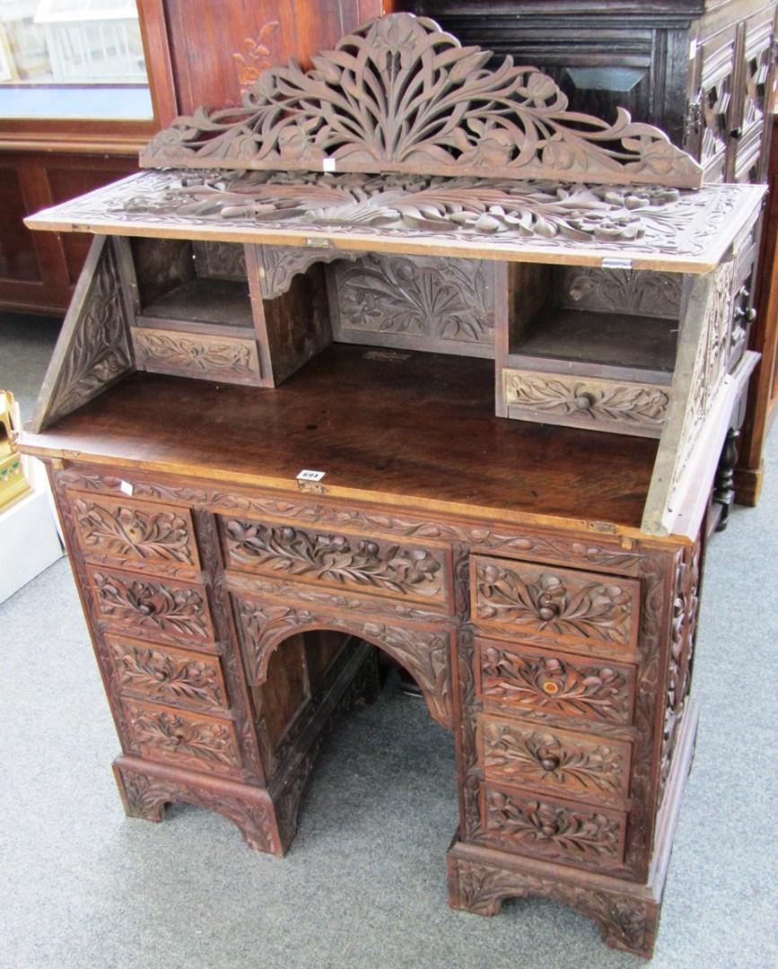 Appraisal: A late th century Anglo-Indian carved teak kneehole bureau cm