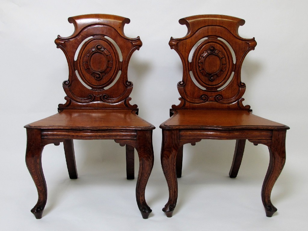 Appraisal: A pair of Victorian oak hall chairs with shaped tops