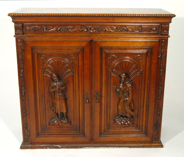 Appraisal: Walnut cupboard heavily carved with swag frieze and two medieval