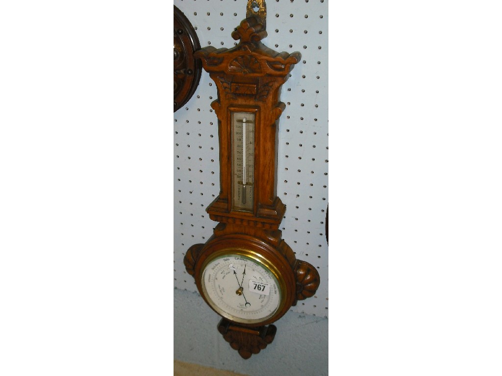 Appraisal: Oak barometer thermometer the white dial within an architectural foliate