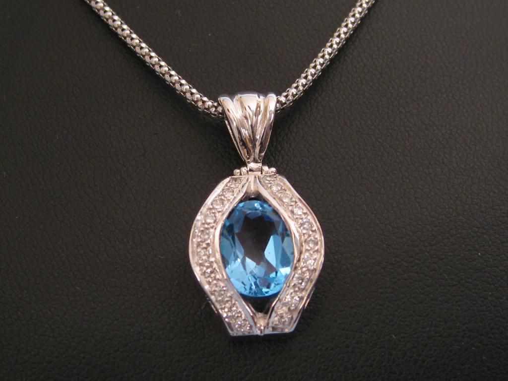 Appraisal: A blue Topaz and Diamond Pendant oval shaped central stone