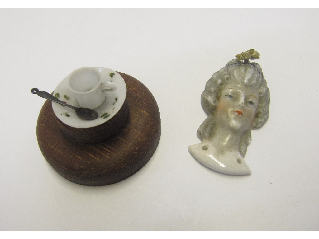 Appraisal: Miniature glass cup and saucer and a porcelain head