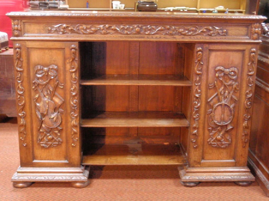 Appraisal: A late Victorian carved oak side cabinet with an open