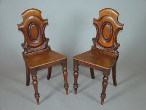 Appraisal: A pair of Victorian mahogany hall chairs with shaped moulded