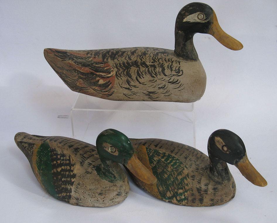 Appraisal: THREE CARVED AND PAINTED DECOY DUCKS each naturalistically painted in