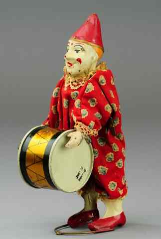 Appraisal: CLOWN WITH BASS DRUM Germany clockwork driven hand painted tin