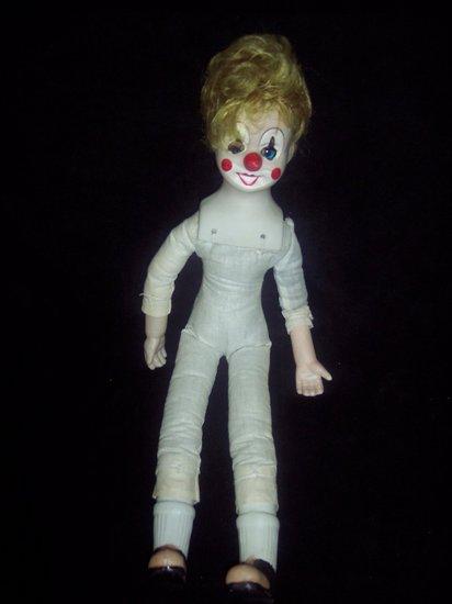 Appraisal: A musical doll dressed as a clown the cloth body