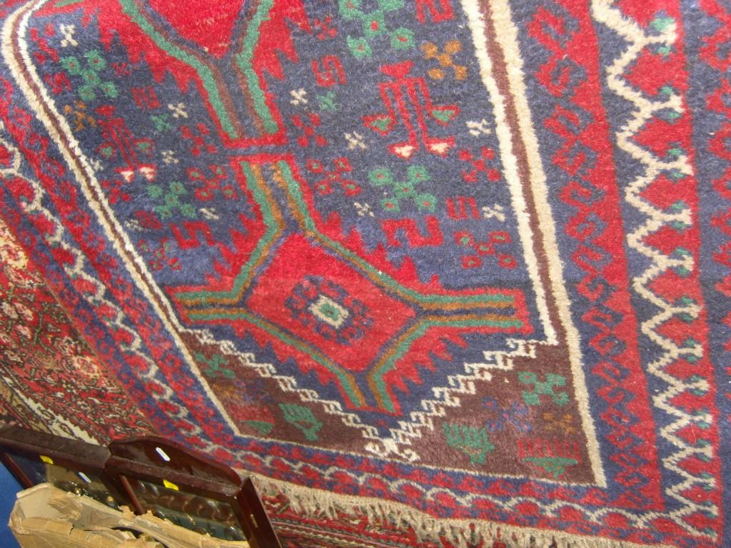 Appraisal: A red ground eastern wool rug with decoration in black