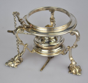 Appraisal: A silver kettle stand with scroll supports and shell feet