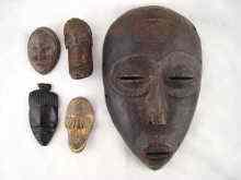 Appraisal: An African tribal mask with pronounced asymmetry together with four