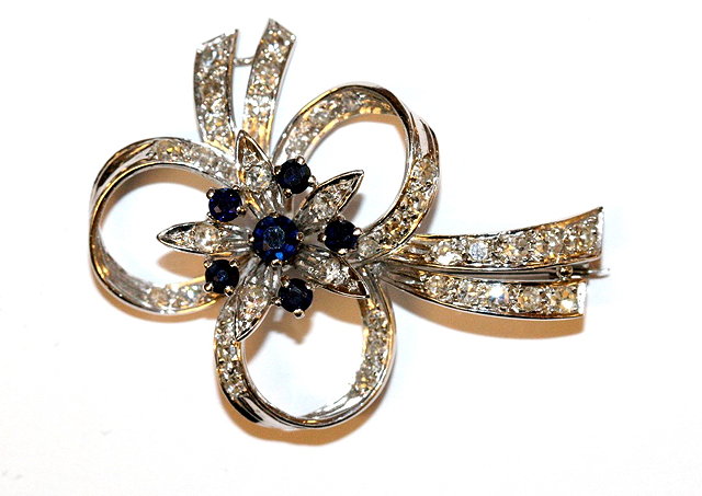 Appraisal: A SAPPHIRE AND DIAMOND FLORAL SPRAY BROOCH with central flower