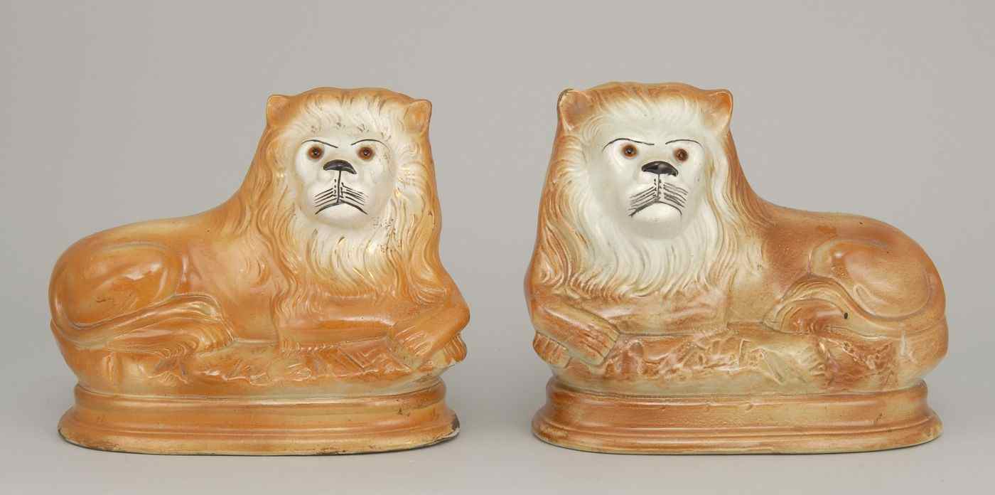 Appraisal: PAIR OF STAFFORDSHIRE LIONSLate th Early th CenturySeated on oval