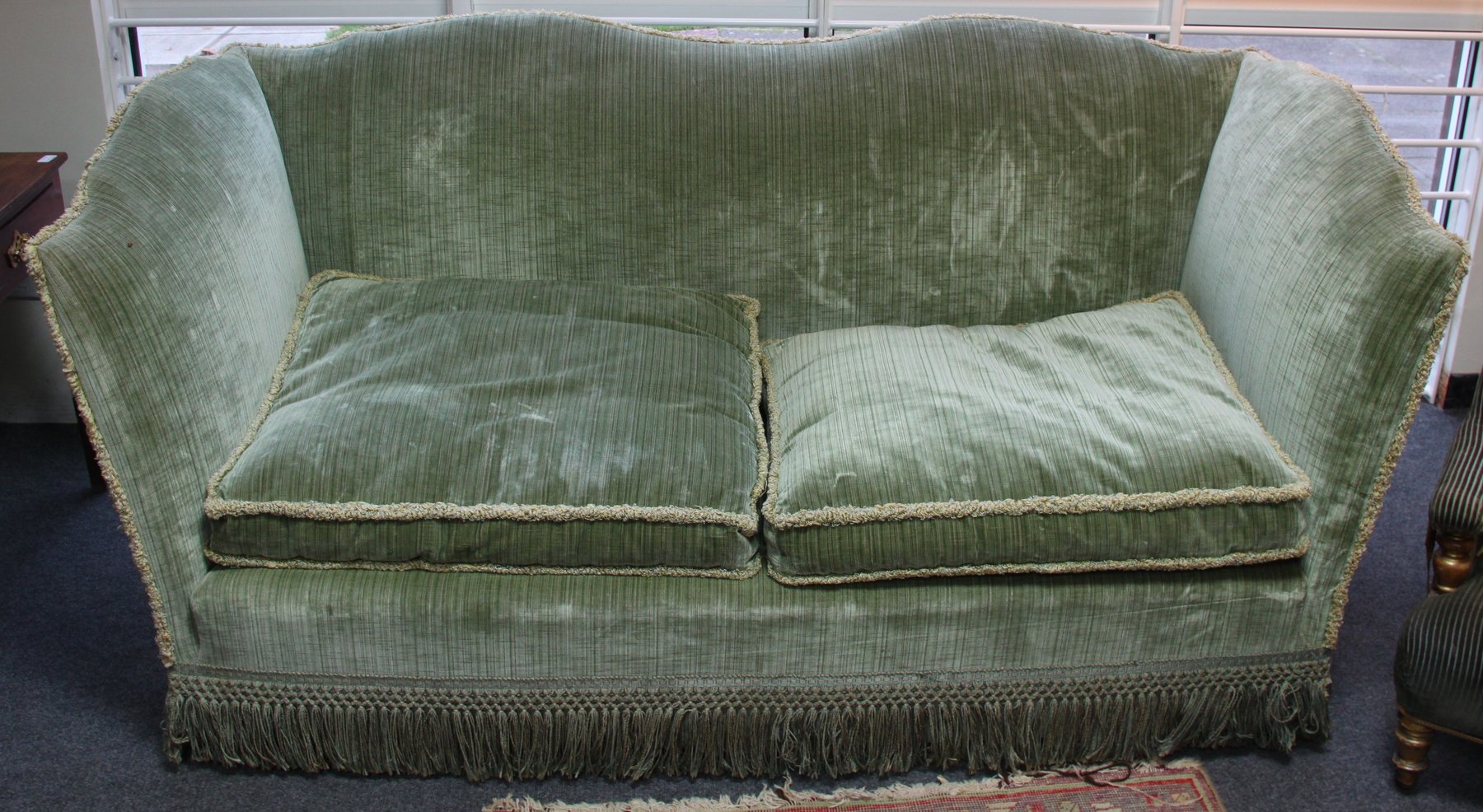 Appraisal: An upholstered settee with arched back and sides on brass