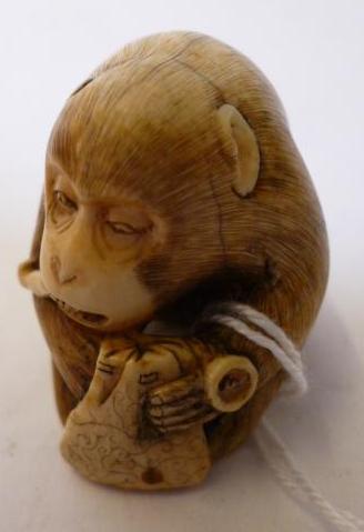 Appraisal: A JAPANESE IVORY NETSUKE carved as a seated monkey smoking