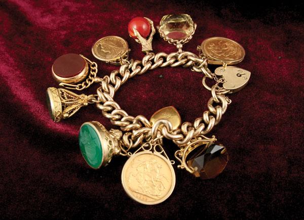 Appraisal: A chain link Charm Bracelet with two Victorian sovereigns half