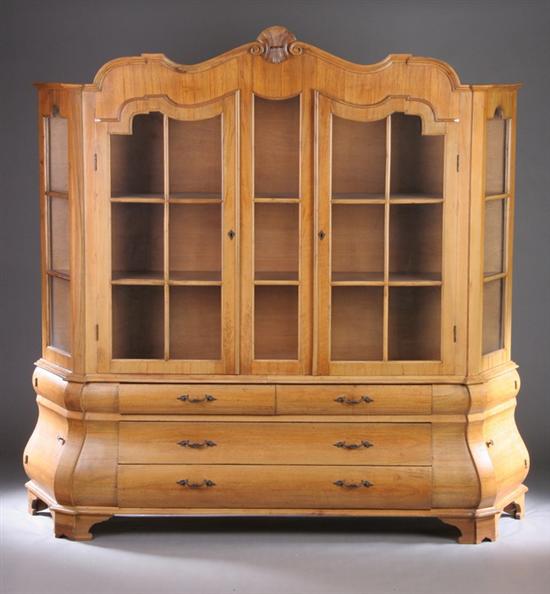 Appraisal: BAROQUE-STYLE LEMON WALNUT BOMBE BOOKCASE Mid th century Shell-carved serpentine