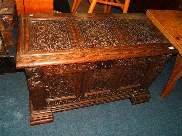 Appraisal: An antique oak coffer with triple panelled carved lid and